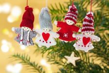 Fire små julefigur der hænger på en grangren